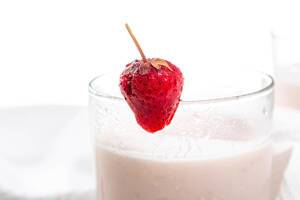 Strawberry yogurt in a glass with fresh berries close-up