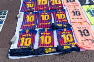 Street vendor sells Lionel Messi FC Barcelona soccer jerseys and Kylian Mbappé Merchandise at a flea market in Spain