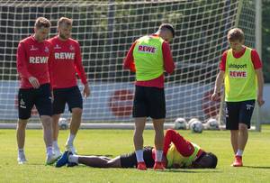 Sturm-Spieler Jhon Córdoba liegt verletzt auf dem Boden während des Fußballtrainings des 1. FC Köln