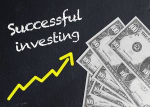 Successful investing with rising yellow trend arrow next to American money