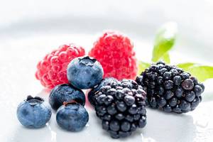 Summer berries of raspberry, blueberry and mulberry on white background