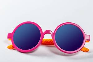 Sunglasses pink-orange colors on white. Kid