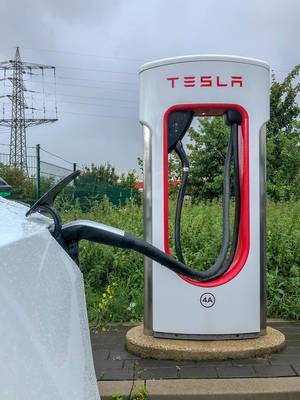 Supercharger Ladesäule für E-Autos: Tesla Model 3 lädt an der Stromtankstelle in Erftstadt, NRW