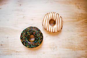 Sweet donuts on white wooden background