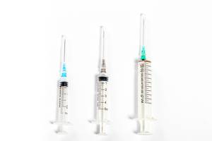 Syringes of different size on white background. Top view