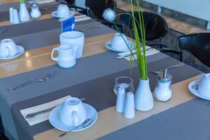 Table ready laid with coffee mugs and silverware