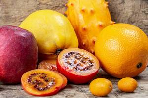 Tamarillo, kumquat, quince, kiwano, orange and apple on a wooden background (Flip 2020)