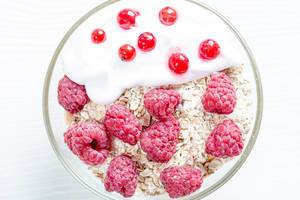 Tasty oatmeal porridge with raspberries and red currant, close up view (Flip 2019)