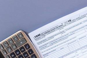 Tax form 1040 and a calculator. US tax form law document. Business concept