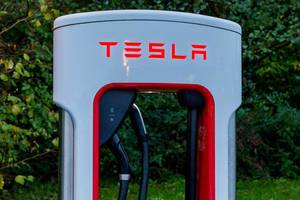 Tesla charging station close up with a greenery background