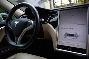 Tesla Model S interior and battery indicator shown on the touch screen, while using Supercharger charging network