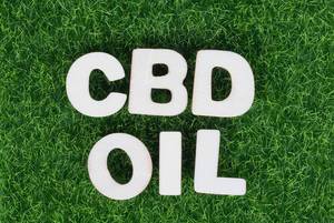 Text CBD oil on green grass background
