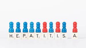 Text Hepatitis A written on wooden blocks with pawns in various colors on white background
