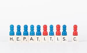 Text Hepatitis C written on wooden blocks with pawns in various colors on white background