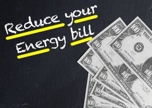 Text REDUCE YOUR ENERGY BILL (Reduziere deine Energiekosten) neben Banknoten