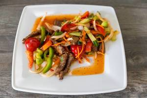 Thai Mittagessen mit Rindfleischstreifen, Paprika rot/grün, Gurke, Zwiebel, Karotten, Chili, Zitronensaft, Selleriekraut, Tomaten und Fischsauce