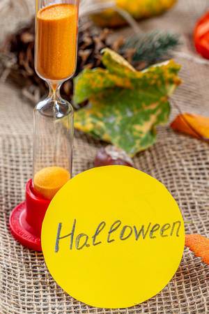 The concept of the imminent onset of Halloween. Hourglass and Halloween tag