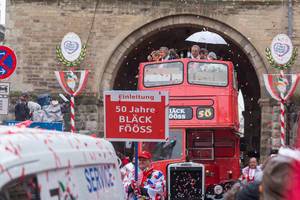 The float celebrating the 50th anniversary of one of the most successful music bands connected to Carnival in Cologne, Bläck Fööss, is a red double-decker bus