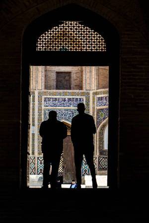 The Mir-i-arab Madrassah seen beyond the doors of the Kalon Mosque, Bukhara, Uzbekistan