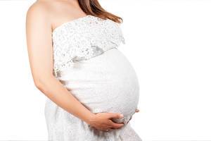 The pregnant girl holds hands a big belly on a white background