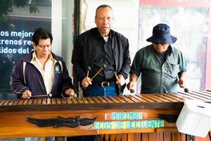 Three men playing the marimba in public