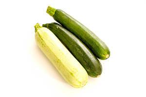 Three raw green zucchini on white background