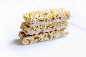 Three stacked granola bars with pink cream