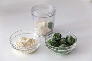 Tiefgefkühlte Spinat-Röllchen und weißes Mandelpulver in Glasschalen, vor einen gesunden Proteindrink