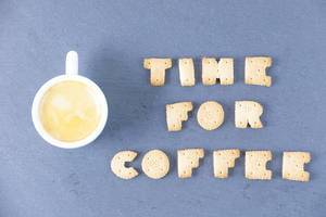 Time for coffee written with biscuit shaped letters, coffee cup