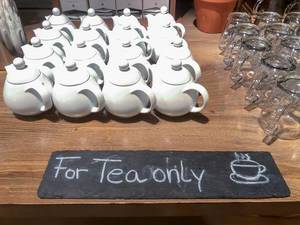 Tiny white teapots with a "For Tea only" slate plate at Pentahotel Berlin, Köpenick
