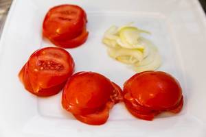 Tomato slices and onion slices on a plate