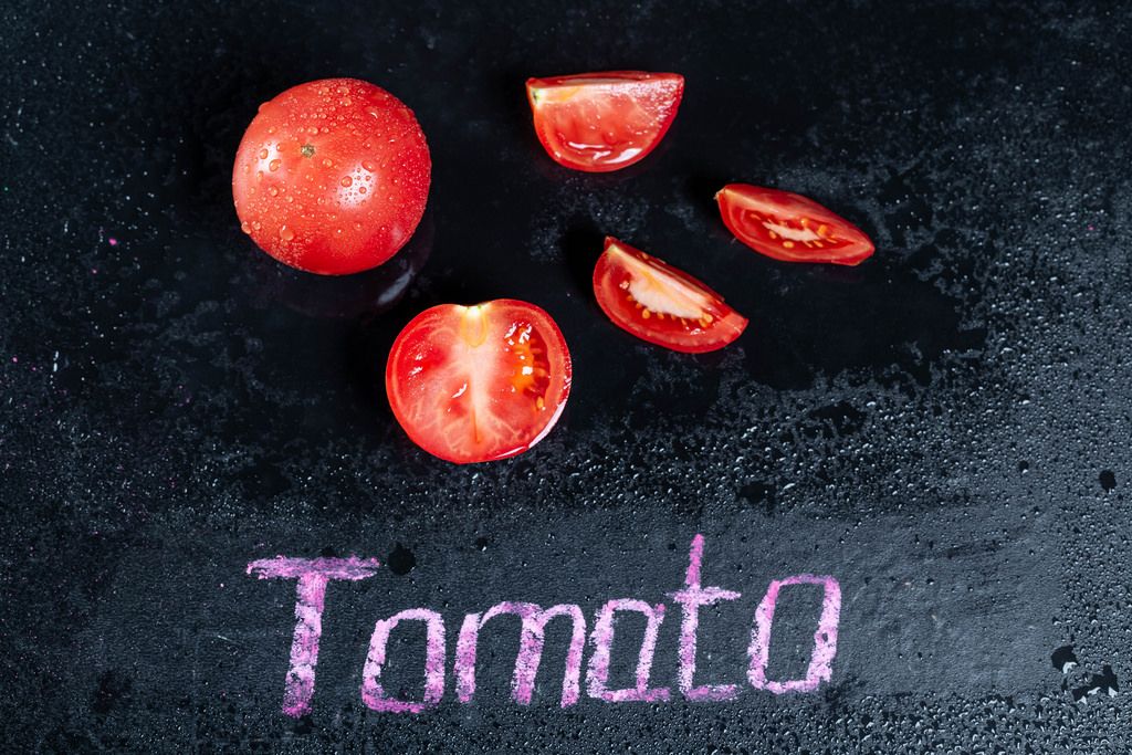 Tomato slices and whole with water drops with the inscription