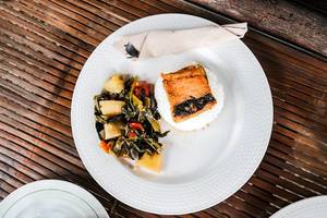 Top shot of a milkfish dish with vegetables on side