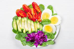 Top view boiled eggs with spinach, avocado, purple cabbage and tomatoes (Flip 2019)