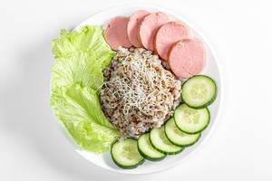 Top view buckwheat porridge with sausage, lettuce, cucumber and alfalfa micro greenery on white background
