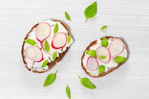 Top view cheese sandwiches with radish slices and Basil leaves white wooden background (Flip 2019)