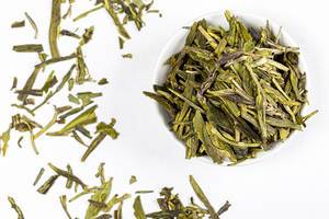 Top view, dried green tea leaves on white background