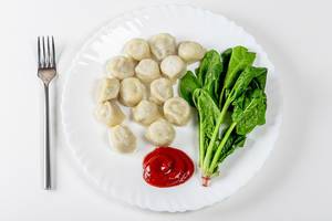 Top view dumplings with spinach and tomato sauce (Flip 2019)