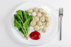 Top view dumplings with spinach and tomato sauce