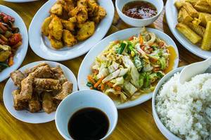 Top View Food Photo of Different Plates of Asian Dishes with Stir-Fried Vegetables, Spring Rolls and Fried Fish with Soy Sauce