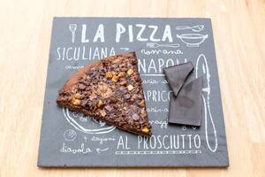 Top View Food Photo of Piece of Chocolate Pizza next to Piece of Dark Chocolate