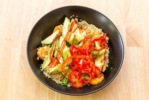 Top View Food Photo of Vegan Bowl with Bell Pepper, Avocado and Quinoa on a Wooden Table