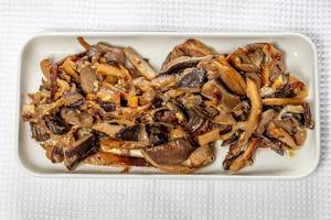 Top view fried oyster mushrooms with onions on a white kitchen towel (Flip 2019)