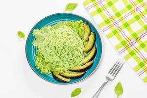 Top view green spaghetti with avocado slices, lettuce and basil (Flip 2019)