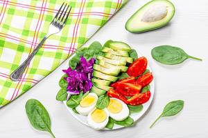 Top view healthy food background. Boiled eggs with fresh vegetables and spinach (Flip 2019)