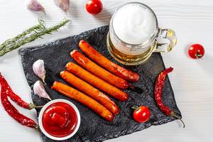 Top view of a light beer with spices and grilled sausages