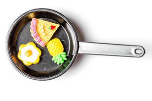 Top view of a small frying pan with food on a white background (Flip 2020)