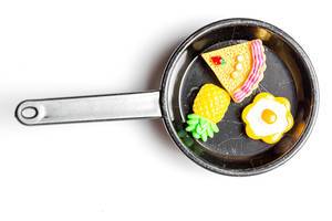 Top view of a small frying pan with food on a white background