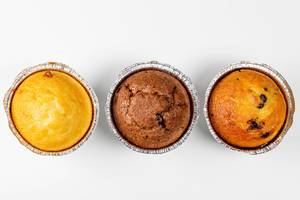 Top view of chocolate, caramel and vanilla muffins on white background (Flip 2019)