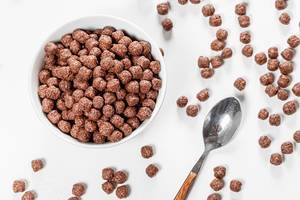 Top view of chocolate corn balls in bowl on white background (Flip 2019)